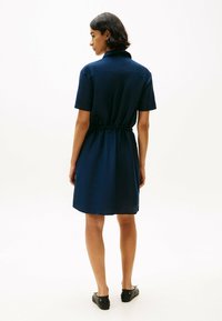 Abito camicia blu navy con colletto, maniche corte, vita elastica e silhouette dritta, realizzato in tessuto liscio, che arriva a metà coscia.