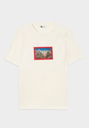 Short-sleeve cream t-shirt featuring a rectangular mountain landscape graphic bordered by a red frame and a brand logo in the corner.