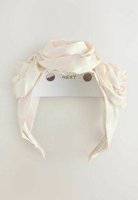 Bandeau en satin blanc avec un design de tissu tordu, doté d'une texture lisse et d'unDos en carton affichant la marque "NEXT."