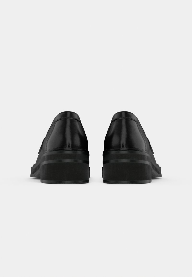 Paire de chaussures habillées en cuir noir avec petits talons empilés, vues de dos sur un fond blanc uni.