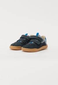 Zapatillas de velcro en ante gris oscuro con un acento texturizado azul, malla gris clara y suela de goma color beige. Adecuadas para uso casual.