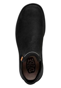 Zapato negro de tipo slip-on con parte superior sintética texturizada, puntera redondeada, costuras contrastantes alrededor del cuello y un logotipo en el interior del zapato.