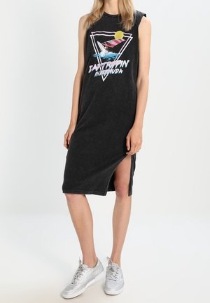 Vestido negro sin mangas hecho de tela suave, con un estampado gráfico en rosa y azul dentro de un diseño triangular. Detalle de abertura lateral.