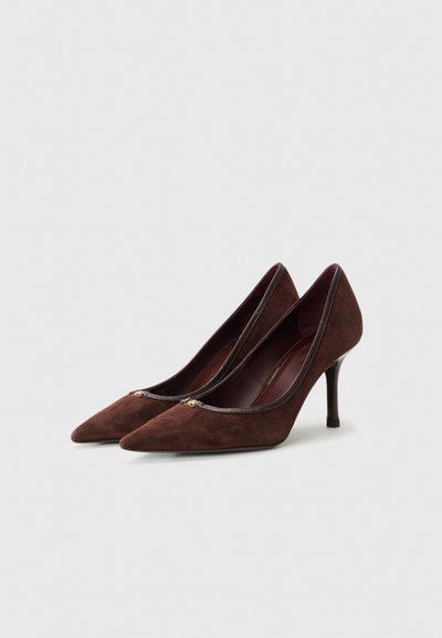 Brown suede high-heeled shoes with a pointed toe, trimmed in dark leather, featuring a subtle gold accent at the vamp.