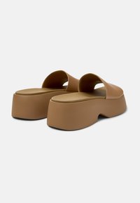 Sandales à talons carrés marron à enfiler avec une texture lisse, dos ouvert et design de bride incurvée. Semelle ergonomique pour le confort.