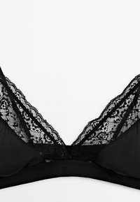 Czarny biustonosz typu braletka z koronkowym wykończeniem przy dekolcie, miękkiego materiału, w kształcie litery V oraz gładkim, bezszwowym wyglądzie.