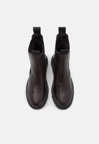 Brown leather ankle boots with a smooth finish, elastic side panels, and black rubber soles. Features pull tabs on the top for easy wear.