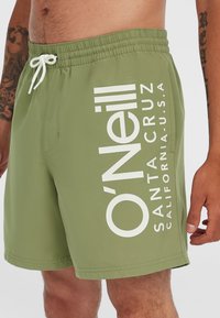 Shorts de bain verts en tissu léger avec un motif graphique blanc incluant "O'Neill", "Santa Cruz" et "Californie, États-Unis."