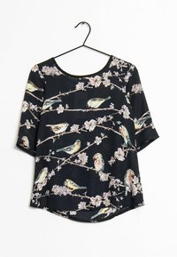 Blouse noire à manches courtes ornée d'un imprimé floral et d'oiseaux. Dotée d'un col rond et d'un ourlet légèrement arrondi.