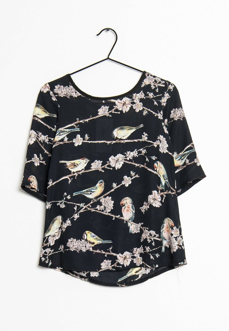 Blouse noire à manches courtes ornée d'un imprimé floral et d'oiseaux. Dotée d'un col rond et d'un ourlet légèrement arrondi.