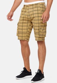 Khaki plaid cargo shorts with a relaxed fit, featuring multiple pockets, a button closure, and a durable fabric texture.