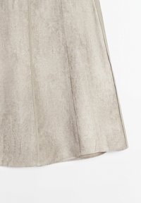 Jupe trapèze en suède beige clair avec des détails de coutures verticales et un ourlet légèrement évasé sur fond blanc.