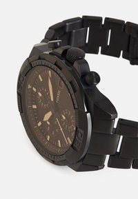 Zwarte chronograafhorloge met een matte afwerking, een gestructureerde bezel en een band van roestvrij staal. Beschikt over drie sub-dial en een datvenster.