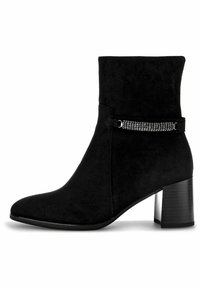 Bottine en suede noire avec un talon bloc, dotée d'une sangle décorative ornée de rhinestones autour de la cheville. Texture lisse avec un bout pointu.