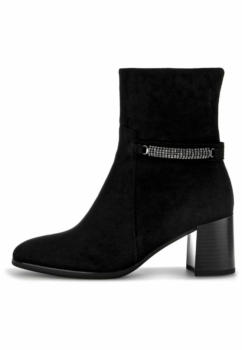 Bottine en suede noire avec un talon bloc, dotée d'une sangle décorative ornée de rhinestones autour de la cheville. Texture lisse avec un bout pointu.