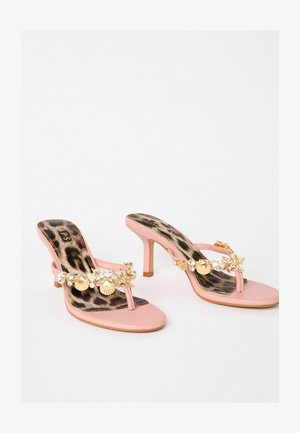 Růžové sandály na podpatku s T-páskem, zdobené zlatými mušlemi a leopardím potiskem na stélce. Hladký povrch, štíhlý podpatek.