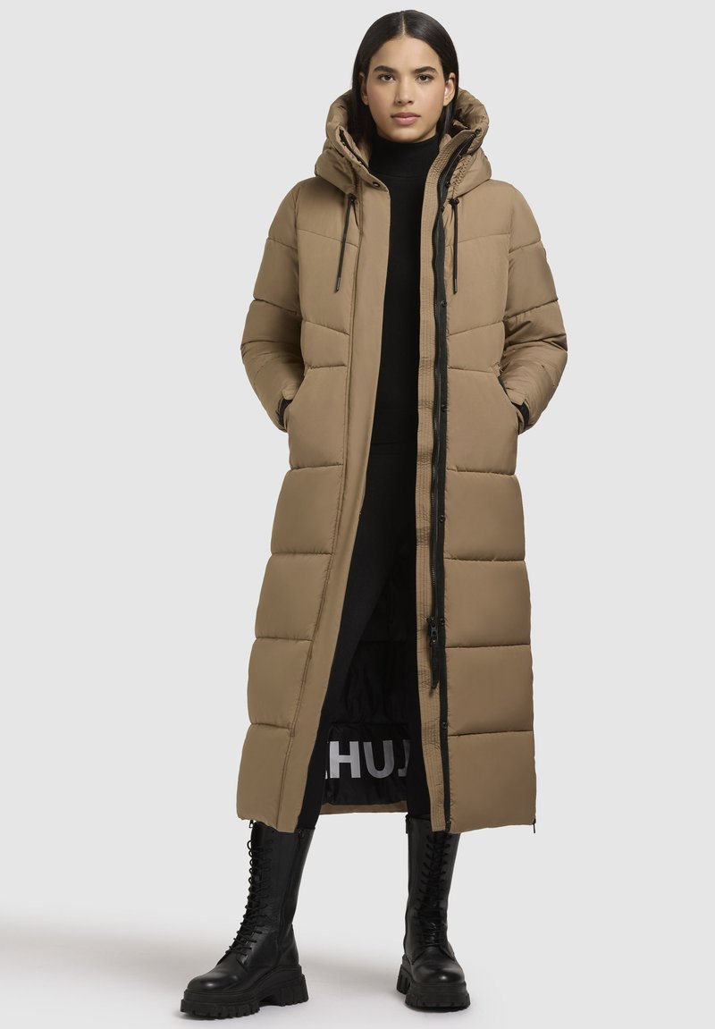 Lange, tan kleurige pufferjas met een capuchon, voorzien van een ritssluiting aan de voorkant, elastische manchetten en een knielange snit. Getextureerde stof met een quiltpatroon.