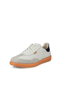 Valkoinen ja harmaa nauhallinen tennari oranssilla pohjalla ja mustalla kantakoristeella, kuvattu vinosti sivusta ja edestä valkoisella taustalla.