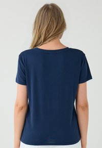 Granatowa koszulka z okrągłym dekoltem i krótkimi rękawami, wykonana z miękkiej tkaniny o gładkiej strukturze. Brak widocznych wzorów lub akcentów.