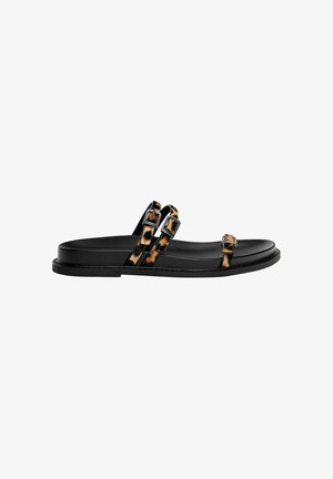 Black flat sandals feature two tortoiseshell-patterned straps with rectangular buckles, smooth midsole, and a textured outer sole.