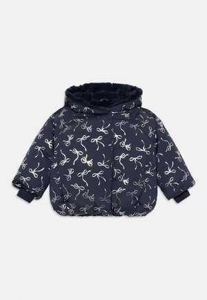 Navy blue puffer jacket with a hood, featuring metallic silver bow patterns. Soft, textured inner lining and elastic cuffs for comfort.