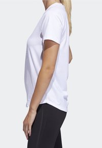 Hvid t-shirt med korte ærmer lavet af glat stof, med en afslappet pasform og rund halsudskæring, kombineret med sorte leggings.