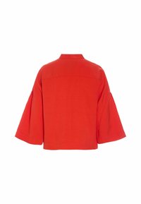 Veste rouge ample avec manches larges trois-quarts et un petit col, vue de dos sur fond blanc.