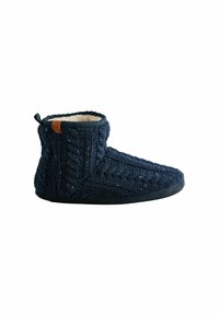 Zapatilla de punto en color azul marino con un suave forro interior. Altura de tobillo con textura trenzada, puntera redonda y suela plana. Presenta un pequeño acento de marca.