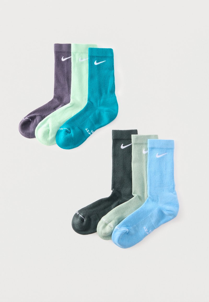 Trois paires de chaussettes montantes Nike en violet, vert menthe et sarcelle au-dessus de trois paires en vert foncé, vert clair et bleu clair sur fond blanc.