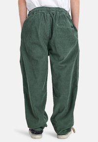 Groene corduroy broek met een relaxte pasvorm, elastische tailleband, zijzakken en subtiele ribbelstructuur. Zichtbare stiksels en casual stijl.