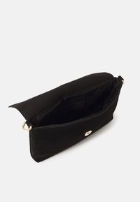 Clutch bag in tessuto nero con una superficie liscia, aperta per rivelare un unico scomparto interno e hardware con pulsante a scatto dorato.