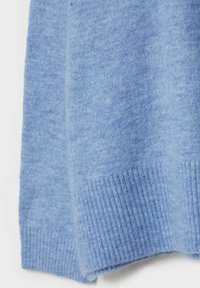 Manche de pull bleu doux en tricot avec détail de poignet côtelé, montrant la texture et le tissage du tissu en gros plan.