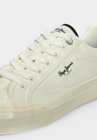 Λευκό sneaker χαμηλού προφίλ με λευκά κορδόνια, λαστιχένια σόλα και λογότυπο "Pepe Jeans London" στο πλάι και στη γλώσσα.