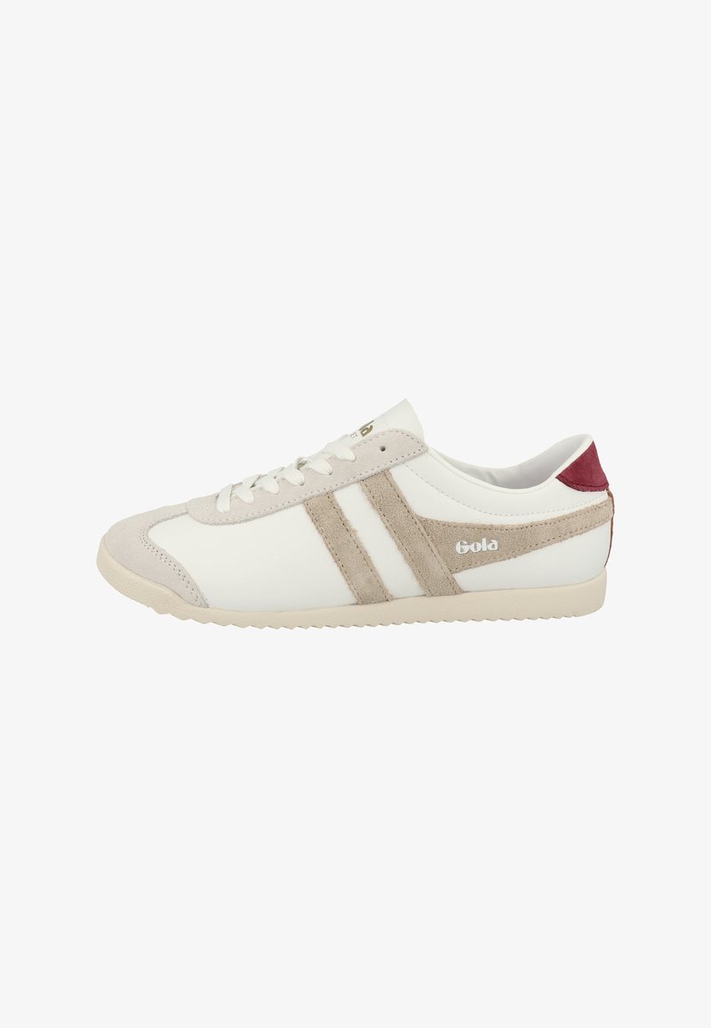 Sneaker bianco con strisce e dettagli in suede beige, punta arrotondata, suola piatta e un tallone rosso. Presenta cuciture tonali e chiusura con lacci.