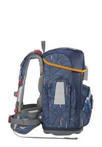 Kinderrucksacktrage mit einem navyblauen geometrischen Muster, gepolsterten grauen Trägern, orangefarbenen Akzenten und Seitentaschen zur Aufbewahrung.