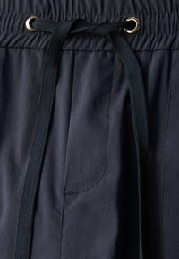 Mørkeblå shorts med elastisk talje og snørelukning, med en enkelt sidelomme og en glat, let stofstruktur.