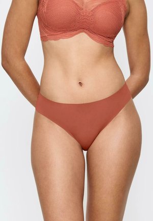 Miękka, gładka tkanina w kolorze terakoty; majtki o średnim stanie z minimalnym zakryciem; bezszwowy design dla komfortu i eleganckiego wykończenia.