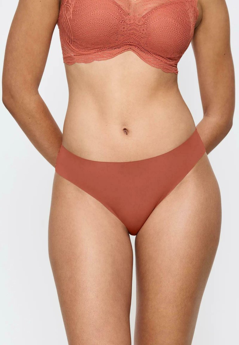 Miękka, gładka tkanina w kolorze terakoty; majtki o średnim stanie z minimalnym zakryciem; bezszwowy design dla komfortu i eleganckiego wykończenia.