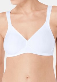 Soutien-gorge sans fil blanc en tissu lisse et texturé, avec des bretelles larges et un décolleté en V. Aucuns éléments métalliques ou ornements visibles.