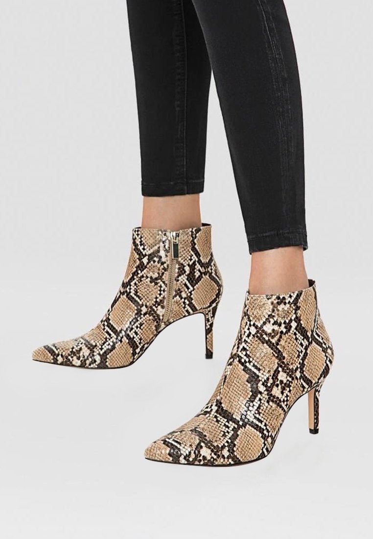 Stivaletti stampati con punta affusolata, caratterizzati da un motivo in pelle di serpente beige e nera, e dettaglio con zip laterale.