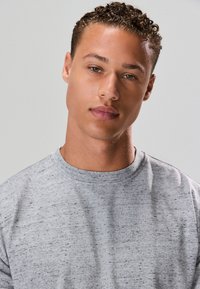 Grijs melange T-shirt met ronde hals en korte mouwen. De stof heeft een zachte textuur met een subtiel gespikkeld patroon.