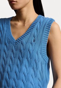 Hellblaues, ärmelloses Cable-Knit-Pullover mit V-Ausschnitt. Bietet strukturierte Nähte und gerippte Abschlüsse und zeigt ausgeklügelte Muster.