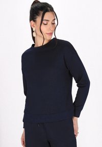 Felpa di colore blu navy con trama, dotata di scollo a girocollo, caratterizzata da un motivo geometrico e maniche lunghe, abbinata a pantaloni coordinati.