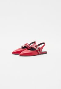 Scarpe slingback rosse con punta affusolata, in materiale di pelle, con cinturino decorativo dotato di borchie argentate e fibbia, suola nera piatta.