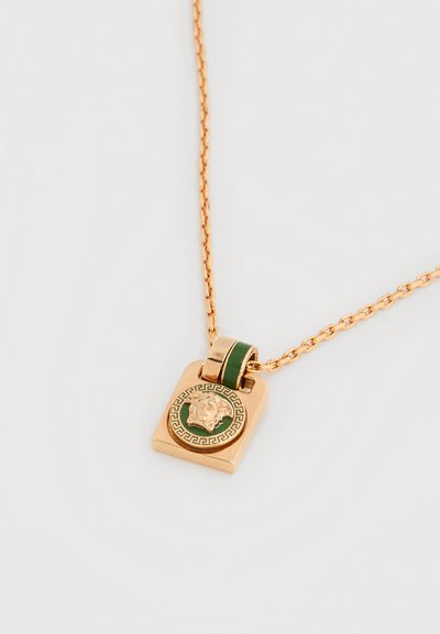 Κολιέ με χρυσή αλυσίδα και χρυσό τετράγωνο μενταγιόν που απεικονίζει μια κλασική κεφαλή Μέδουσας με πράσινες και χρυσές λεπτομέρειες.