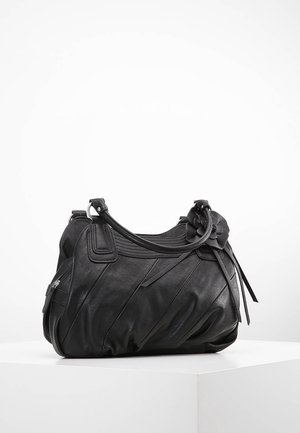 Sac à main en cuir noir avec poignées supérieures, coutures diagonales, poche latérale zippée et fleur décorative sur la poignée, présenté sur une surface blanche.