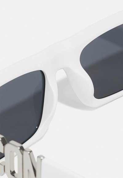 Gafas de sol blancas con lentes gris oscuro, que cuentan con un diseño moderno y una textura suave. Incluye detalles de hardware metálico que acentúan la montura.