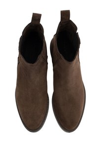 Un par de botas de ante marrón hasta el tobillo con lengüetas y punteras redondeadas, vistas desde arriba sobre un fondo blanco.