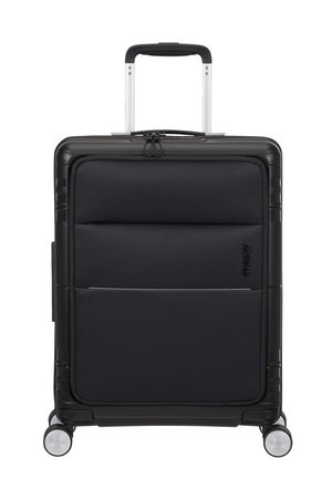 Valise rigide noire avec une finition texturée, dotée d'une poignée télescopique, de quatre roues et de plusieurs compartiments zippés.