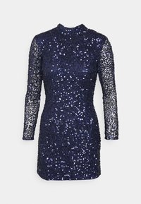 Vestido de marinha com mangas longas, transparentes e com lantejoulas. O corpo é totalmente coberto por lantejoulas, com silhueta justa, decote alto e comprimento curto.